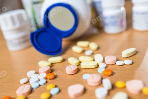Preview: Various colorful medicine tablets on wooden table