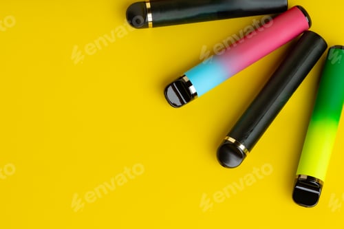 Preview: Colorful disposable electronic cigarettes on yellow background