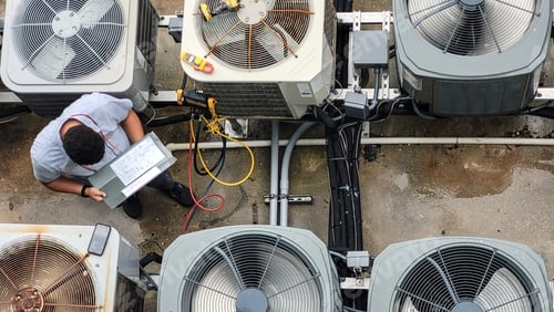 Preview: Young Latino HVAC technician doing paperwork while working on Maintenance of HVAC systems.