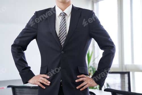 Preview: A Japanese male businessman waits in a conference room with his hands on his hips