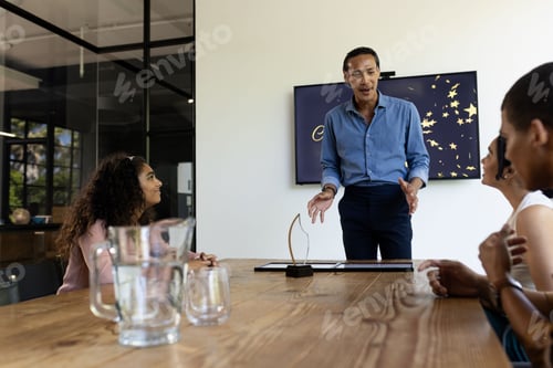 Preview: Business meeting, diverse team discussing presentation with award on table