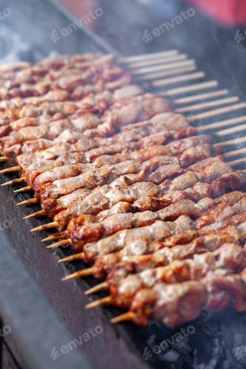 Preview: A lot of juicy meat kebabs in a row on the grill.