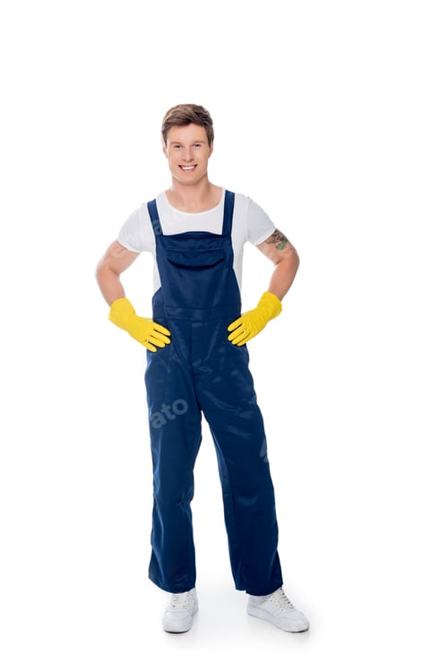 Preview: smiling cleaner in uniform standing akimbo isolated on white