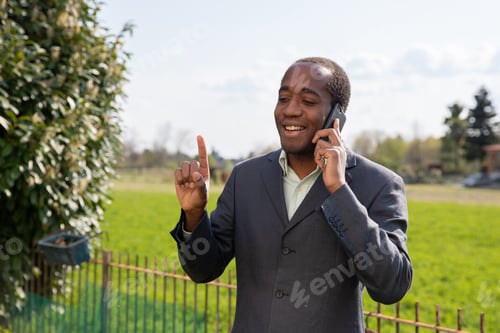 Preview: Successful positive african american businessman makes a phone call with a customer.