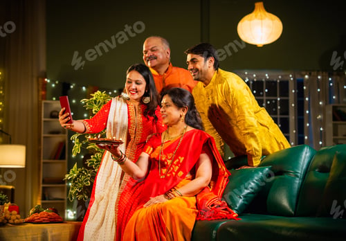 Preview: Smiling Indian family celebrating Diwali indoors with decorations enjoying festival moments together