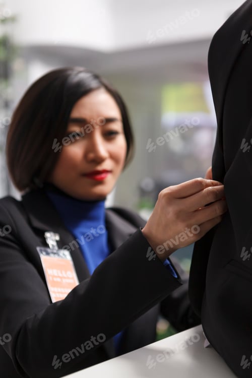 Preview: Seller fastening jacket on mannequin