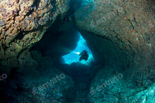 Preview: Scuba Diver with LIght Enters Coral Cavern