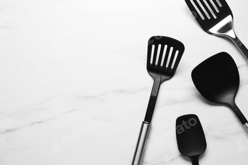 Preview: Different spatulas on white marble table, flat lay. Space for text