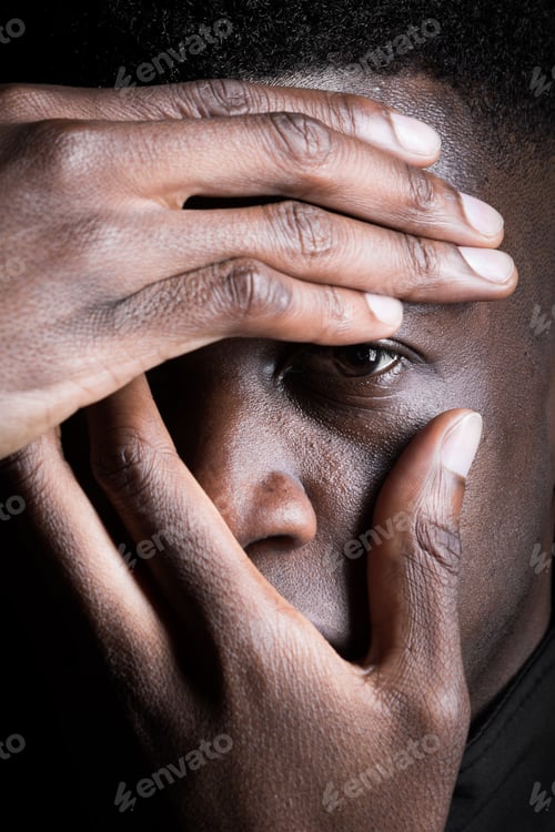Preview: Close-up studio portrait of a black man with expressive pose against black background