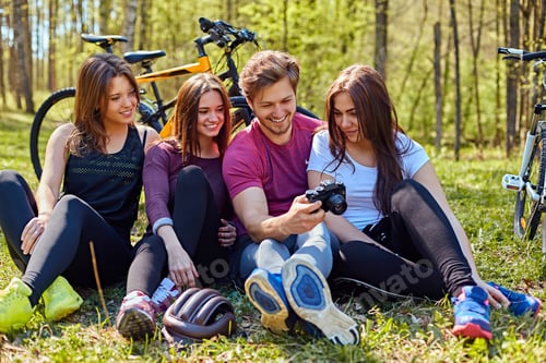 Preview: Groupe of people relaxing after bicycle ride in a forest.