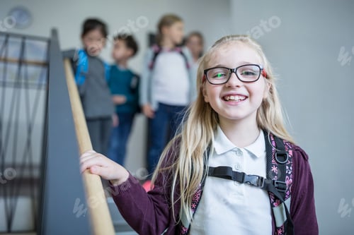 Retrato de colegial feliz com colegas na escadaria saindo da escola