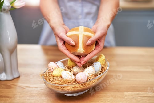 Preview: Happy adult woman preparing hot cross buns for Easter in the kitchen