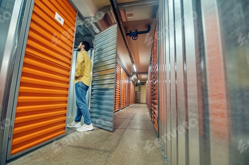 Preview: Man entering open garage door in warehouse