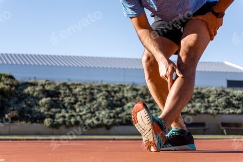 Preview: close-up view of unrecognizable man stretching calf-muscle before start running, copy space,