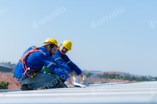 Preview: Both of technicians is installing solar panels on the roof of the warehouse