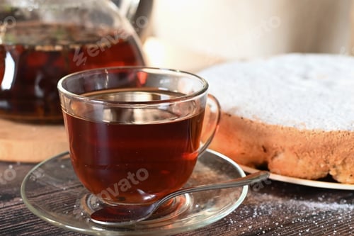 Preview: Glass Cup of Tea with Cake on Table