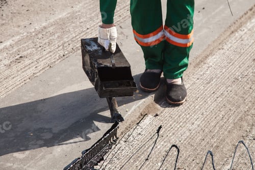 Preview: The man working asphalt pouring tar for road repair