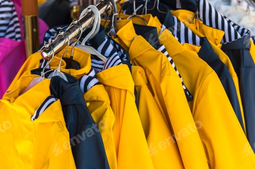 Preview: Bright raincoats hanging at a fashion store