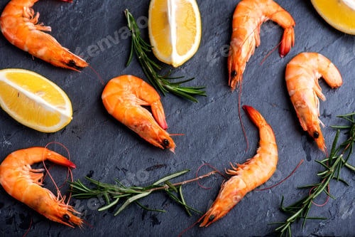 Preview: Top view of shrimps with lemon and rosemary on black background.