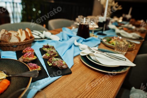 Preview: Beautifully laid tables with food, glasses and appliances in restaurant.