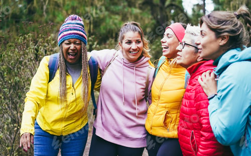 Preview: Multiracial women having fun during trekking day in mountain forest - Focus on african female hat