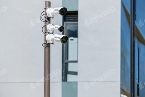 Preview: CCTV multi angle cameras security. Surveillance Video Camera on Pole at building background.