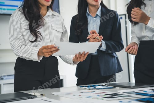 Preview: Businesswomen analyzing financial charts and graphs discussing company strategy