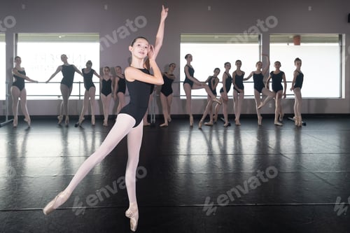 Preview: Teenage girl in ballet dance studio poses with the rest of the class behind her