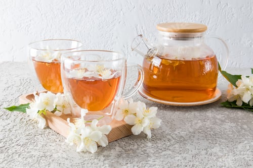Preview: Front view double bottom glass cup with fragrant jasmine tea, jasmine flowers. tea ceremony.