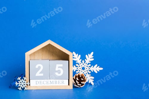 Preview: 25 december. Christmas composition on colored background with a wooden calendar