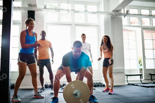 Preview: Young man lifting weights with friends cheering in the background