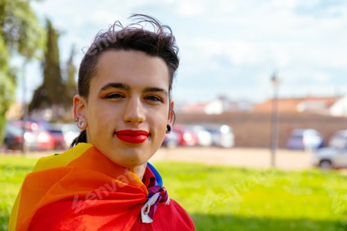 Preview: Portrait of a Caucasian transgender girl with the gay flag on her shoulders