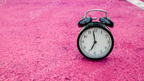 Preview: Retro black alarm clock on pink background with copy space.