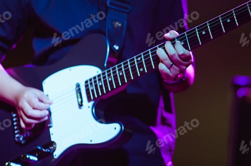 Preview: man playing guitar on a stage musical concert close-up view.guitarist plays.