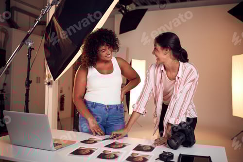 Preview: Photographer With Female Client Editing Images From Portrait Photo Shoot In Studio