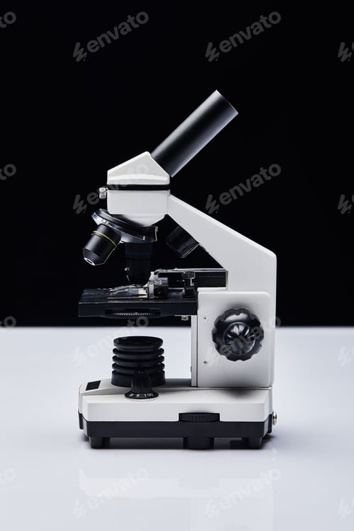 Preview: modern microscope on white table isolated on black