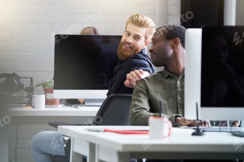 Preview: Smiling bearded man getting attention of his male colleague
