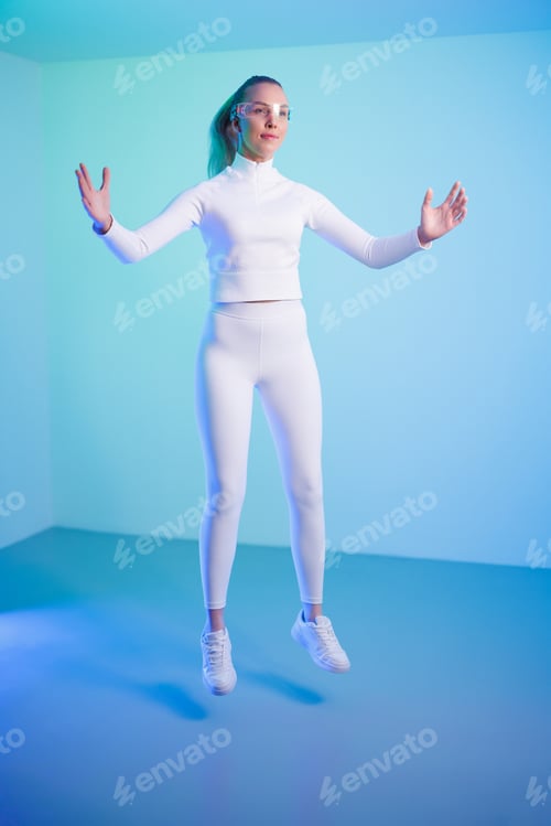 Preview: Female in smartglasses jumping against blue background