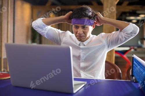 Preview: Young businessman using laptop on table tennis table