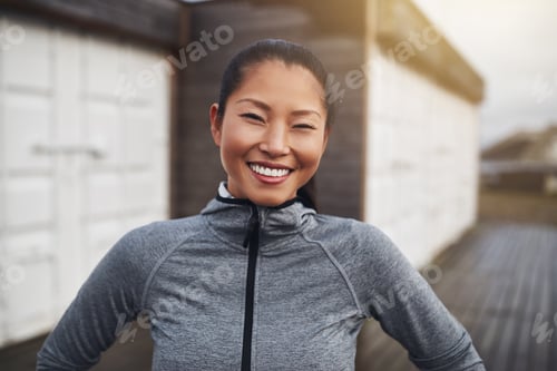 Preview: Smiling young Asian woman in sportswear out for a jog