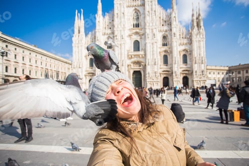 Preview: Winter travel, vacations and birds concept - Young happy woman tourist with funny pigeons making