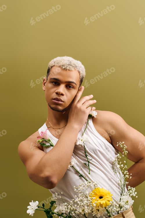 Preview: Young Black man in a stylish tank top surrounded by flowers in a studio