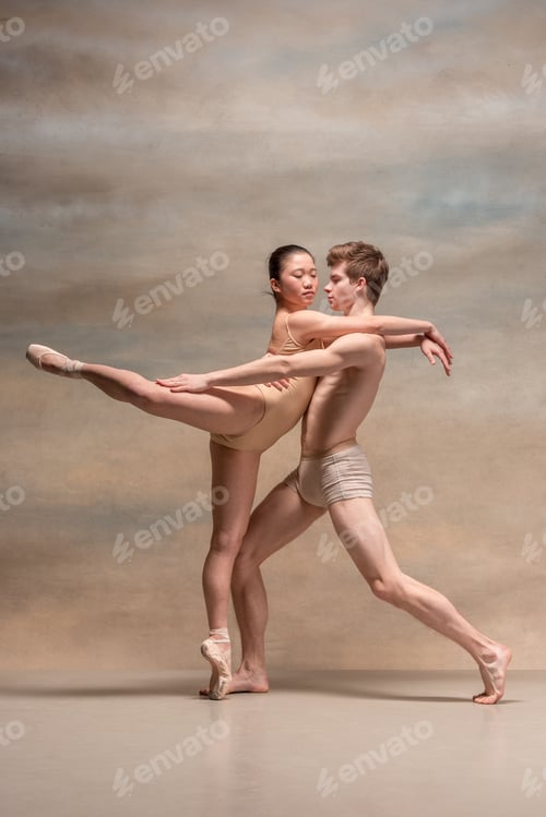 Preview: Couple of ballet dancers posing over gray background