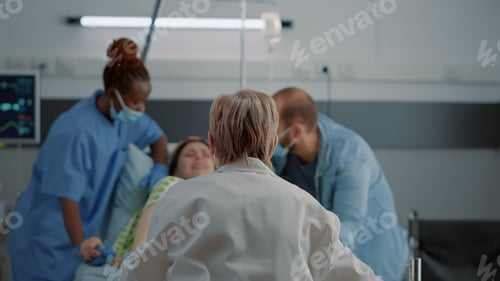 Preview: Doctor and african american nurse helping pregnant woman