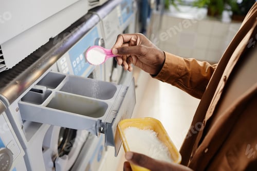 Preview: Hand of African American guy in beige shirt putting cap of soap powder