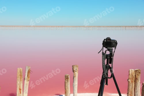 Preview: Professional camera with tripod near pink lake