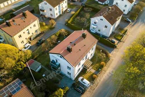 Preview: Aerial view of residential houses with red roofs and streets with parked cars in rural town