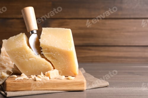 Preview: Parmesan cheese with wooden board and knife on table. Space for text