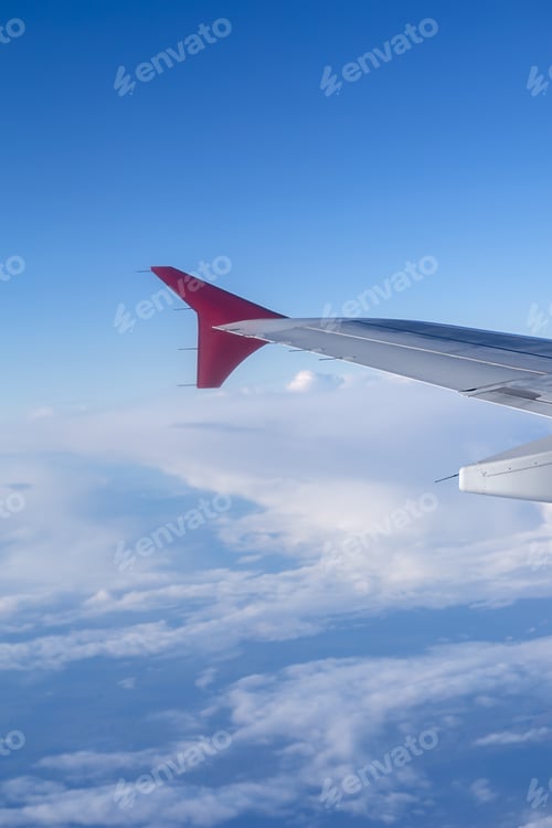 Preview: vertical photo the wing of a flying aircraft against the background of clouds