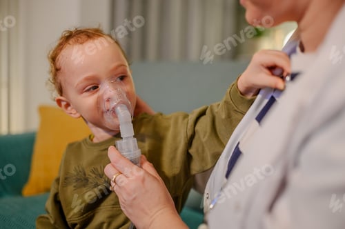 Preview: Toddler playing with doctor's clothes during inhalation treatment.